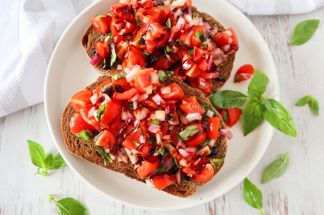 This bruschetta is my absolute favouite lunch right now. I've made it every day for the past week, and it's so good. And if you can find it, I strongly recommend grabbing a bottle of balsamic reduction from the supermarket. I, however, do not recommend trying to make your own, because you'll end up with only a few teaspoons from an entire balsamic vinegar bottle! 😭 It's seriously not worth it! 

This bruschetta is also great to take to work if you have a toaster! Pack the mix separately, and then assemble at work. Aaand of course, you can make it ahead. Just make up a big batch of the topping and keep it in the fridge for the week. 

This is a lunch recipe from my Vegan Families Club. 

Tomato and Basil Bruschetta

Prep Time: 15 mins
Total Time: 15 mins
Servings (total): 4

250g Cherry Tomatoes
½ medium Red Onion
¼ cup Basil Leaves
2 Tbs Balsamic Vinegar
8 slices Thick Sourdough
1 Tbs Minced Garlic

1. To make the bruschetta topping, chop the tomatoes into quarters, finely chop the onion, and tear the basil into pieces. Add to a medium bowl.
2. Pour over the balsamic vinegar and let sit for 10 minutes.
3. Toast the bread, and spread lightly with the minced garlic.
4. Top the toast with the bruschetta mix and serve.#busyveganmom #vegansofig #busyveganmum #veganparents #beginnervegans #veganfood #veganmealprep #veganfamilymeals #Veganuary2022 #vegannutritioncoach #veganparentsofaustralia #vegannutrition #vegannutritionist #veganlunch #veganmealplans #beginnervegan #veganfamilies #veganlunchprep #veganrecipeideas